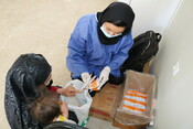 A nutritional nurse gives supplementary foods to Gajalya* and her daughter Nairah*.