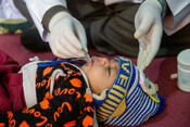 A child is examined by a Dr from the Afghan Red Crescent examines mobile health team.