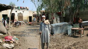 Saeed ur Rehman in front of his destroyed house