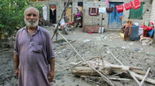 Alam Khan shows the damage done to his house by the flood