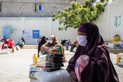 Internally displaced people collect food aid at an Islamic relief distr