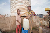 Cousins Hadia*, 7, (left) and Gamila*, 11, (right) collecting water from an IDP Camp in Yemen