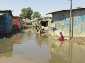A young girl walks through recently flooded Gumbo Market in Juba, South Sudan.
