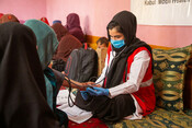 A midwife from one of Afghan Red Crescent's mobile health teams conducts health checks during a regular community visit