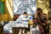 Doctor Roohullah Nekmal of Afghan Red Crescent examines patients during a community visit by his mobile health team.